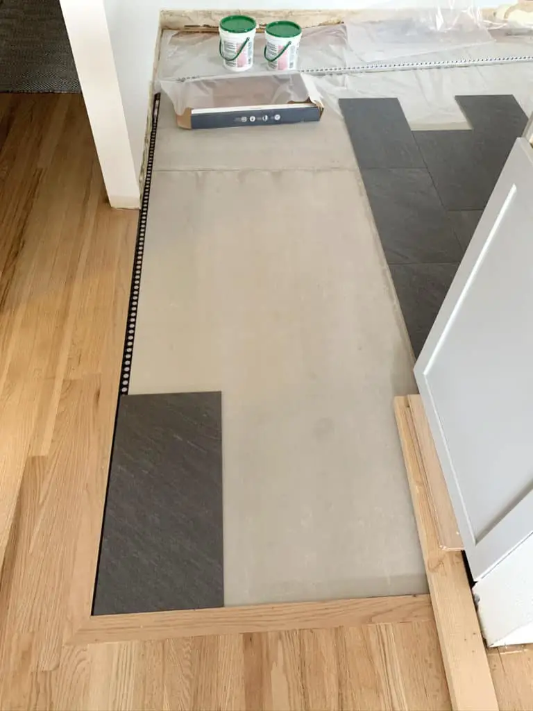 tile in corner of kitchen floor with black trim edging
